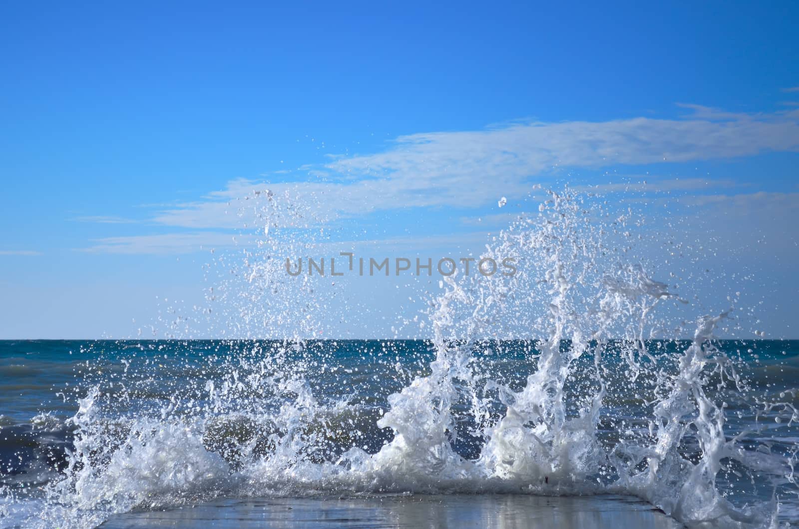 Powerful waves of the sea foam, breaking the concrete pier