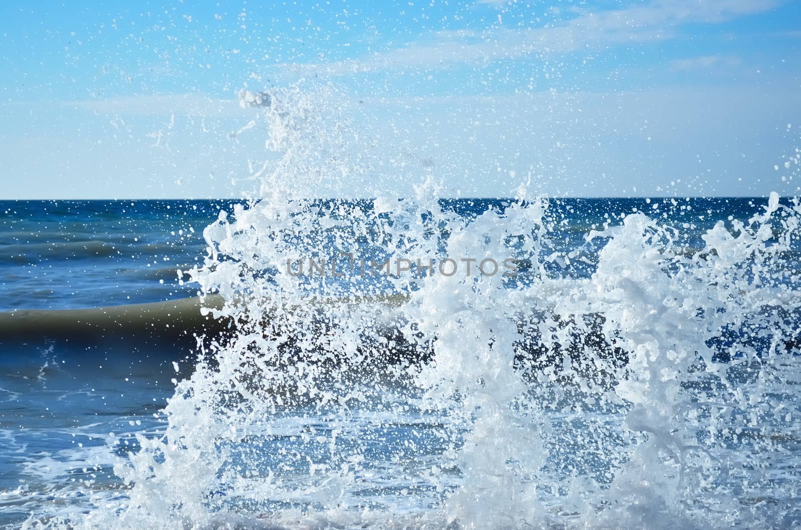 Powerful waves of the sea foaming, breaking against the rocky shore