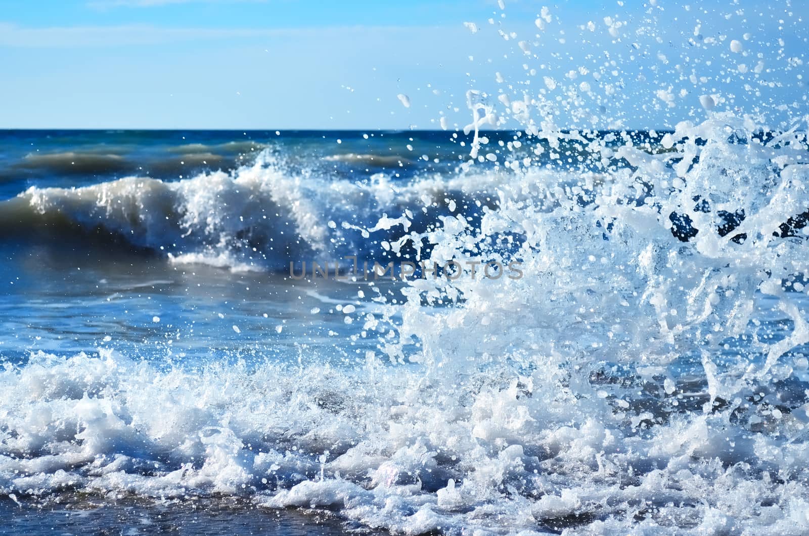 Powerful waves of the sea foaming, breaking against the rocky shore