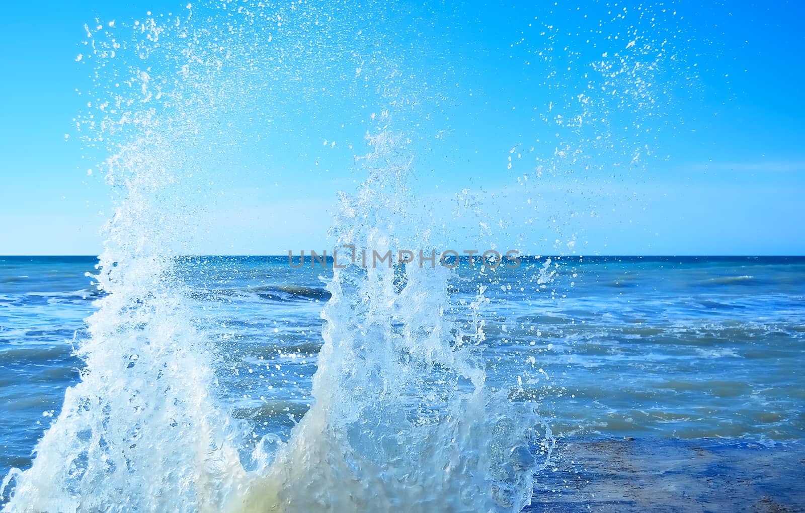 Powerful waves of the sea foaming, breaking against the rocky shore