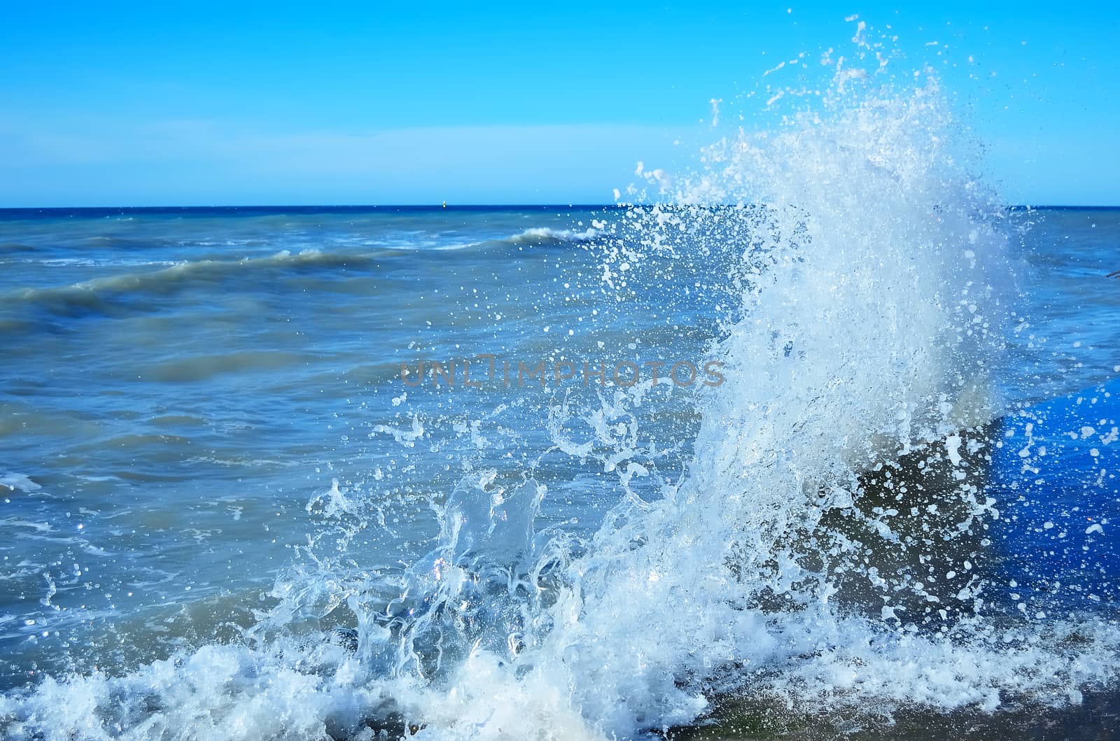 Powerful waves of the sea foaming, breaking against the rocky shore