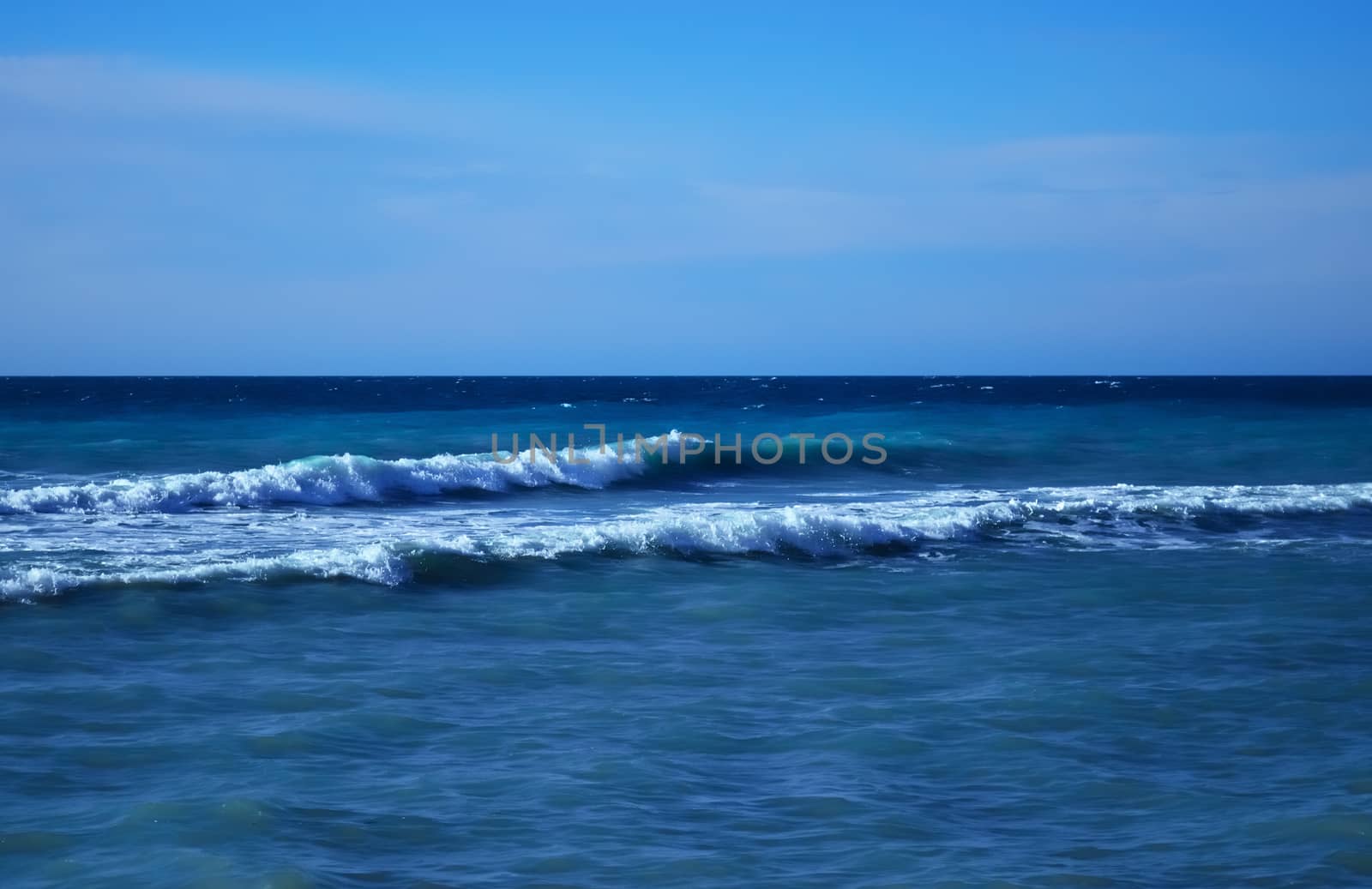 Powerful waves of the sea foaming, breaking against the rocky shore