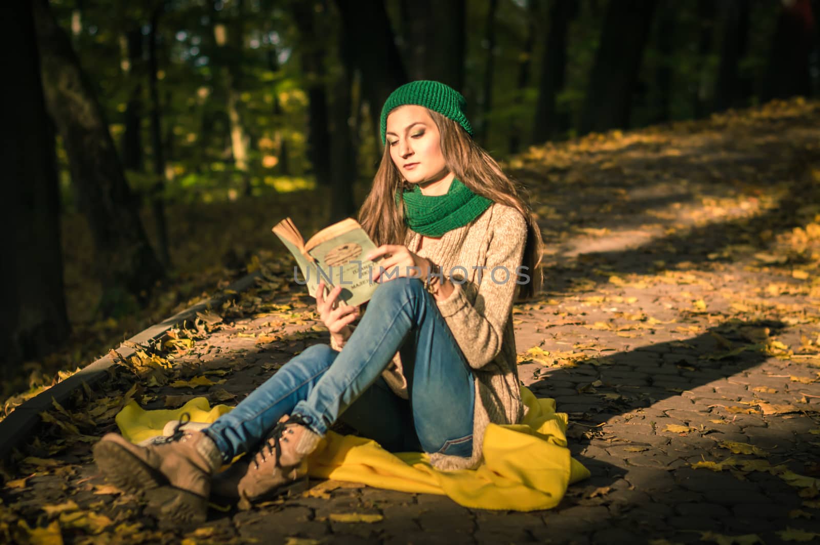 girl reading a book sitting on the track in a Park