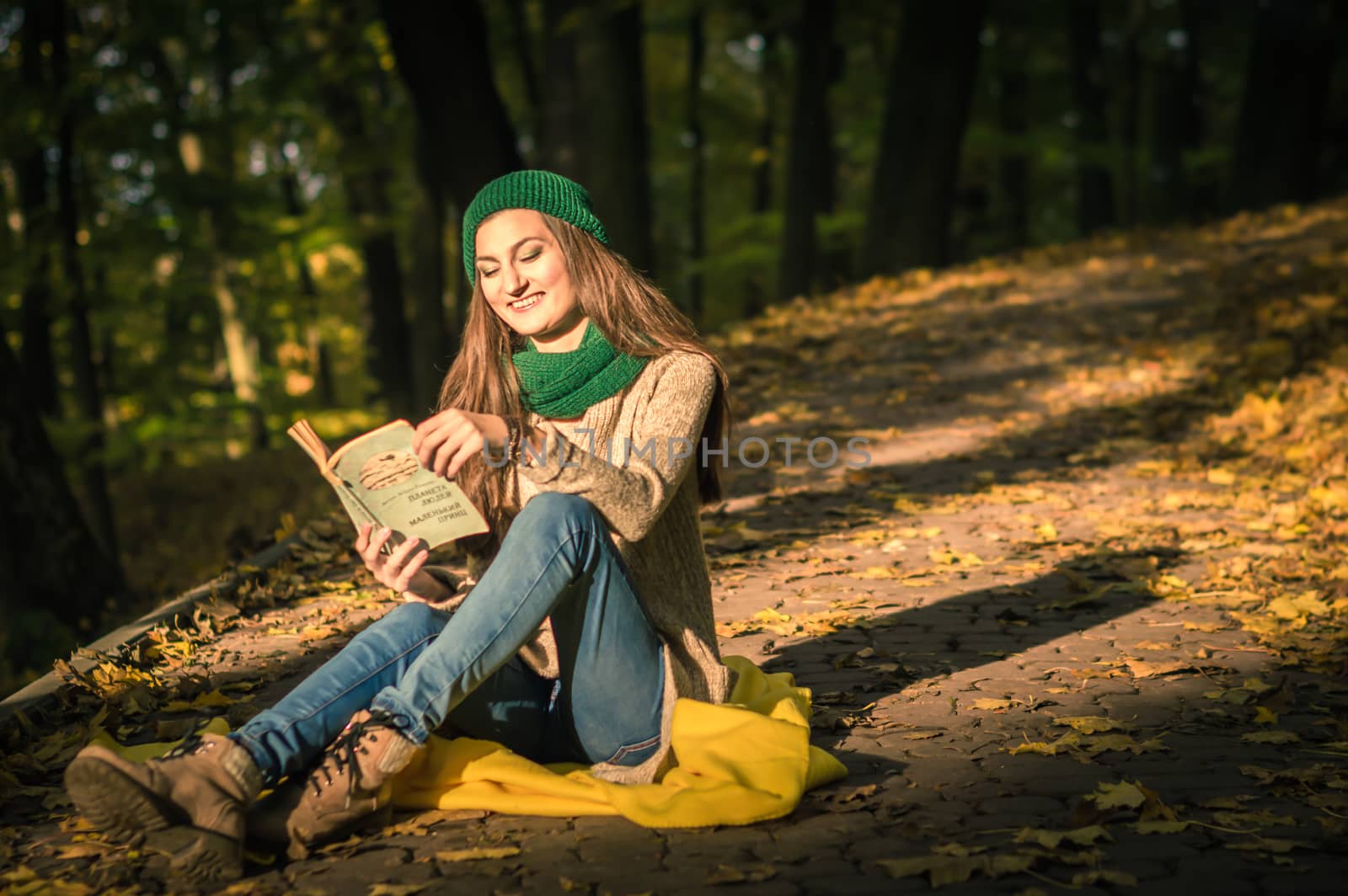 girl reading a book sitting on the track in a Park