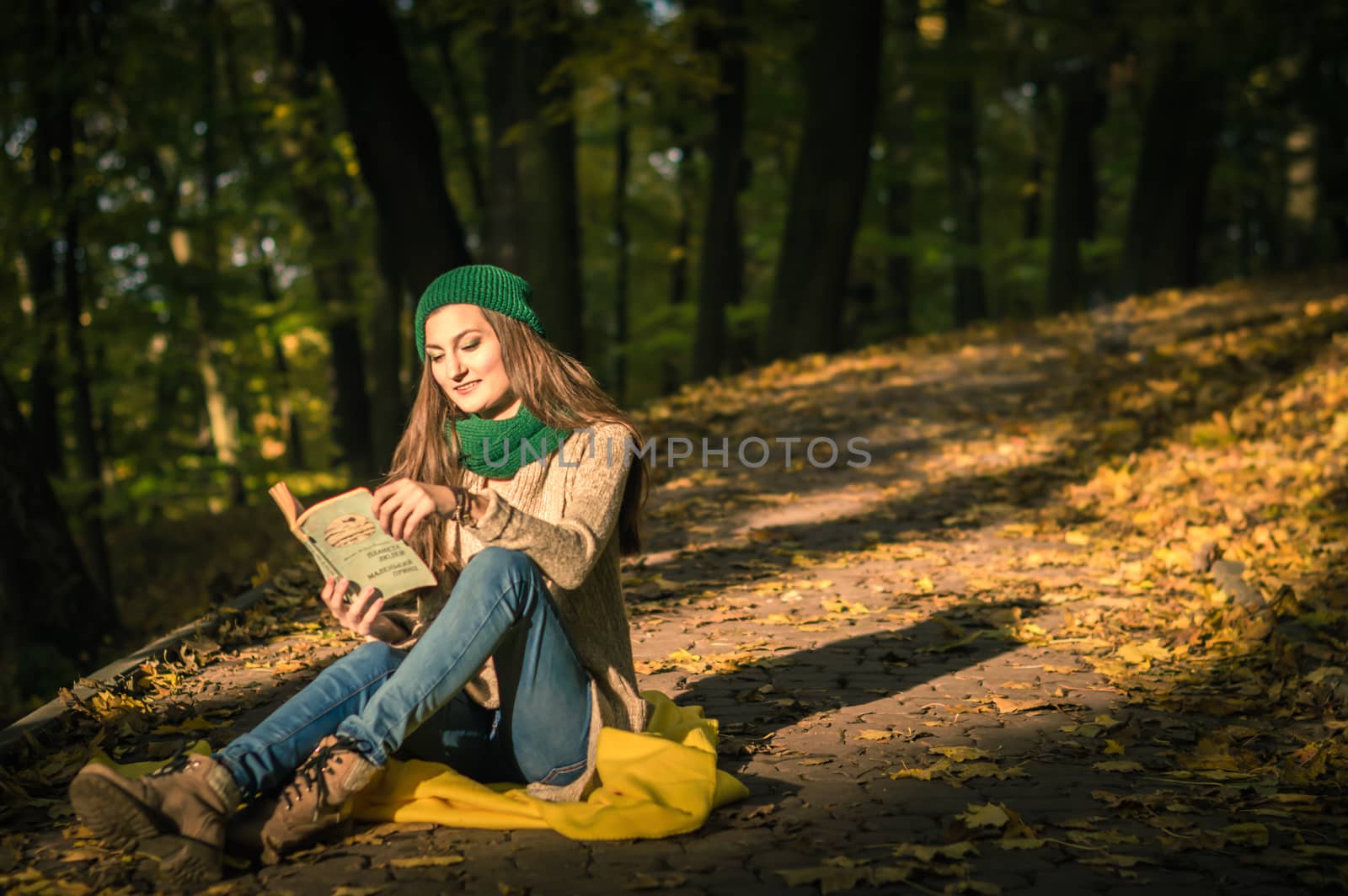 girl reading a book sitting on the track in a Park