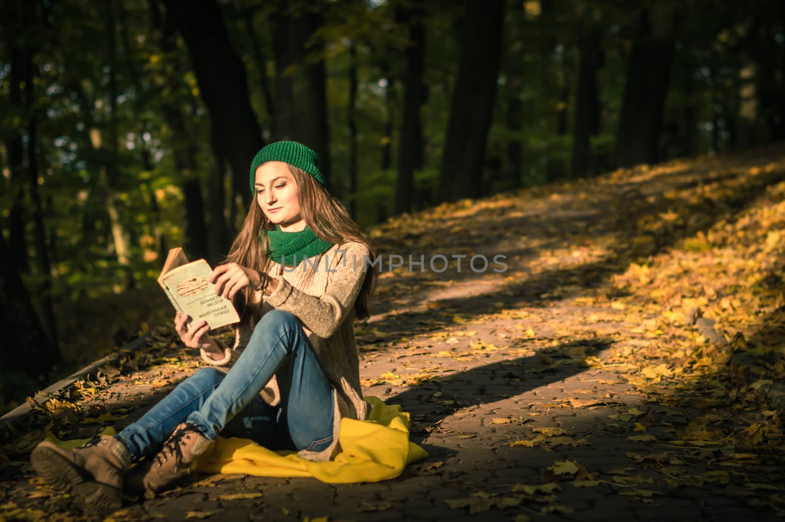 girl reading a book sitting on the track in a Park