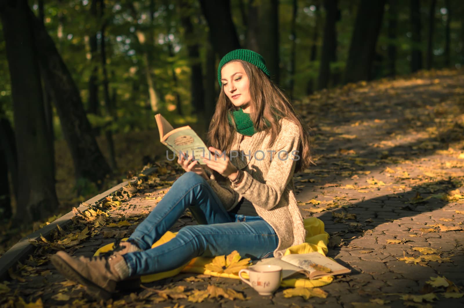 girl reading a book sitting on the track in a Park