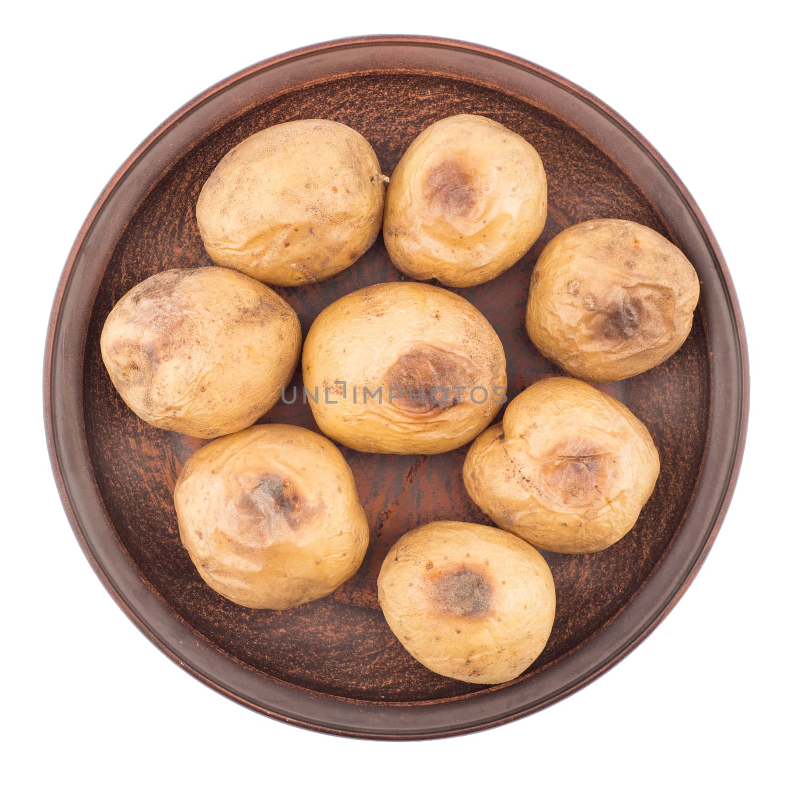 Baked potato in a brown plate isolated on white. Top view.