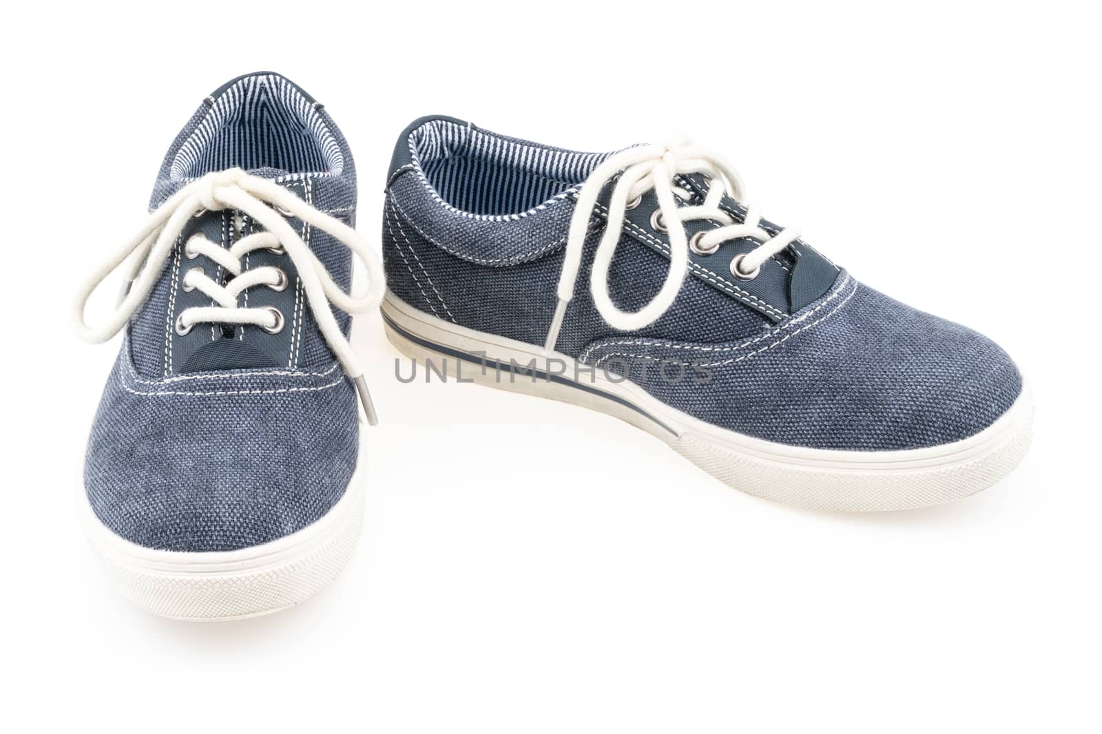 Picture of a pair of blue trainers over a white background. Selective focus.