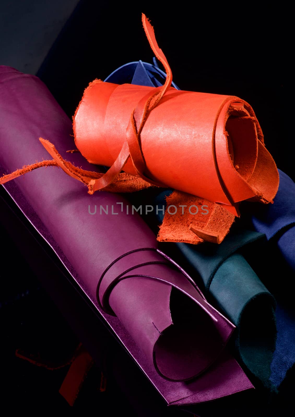 Stack of Colorful Leather in Rolls closeup on Black background