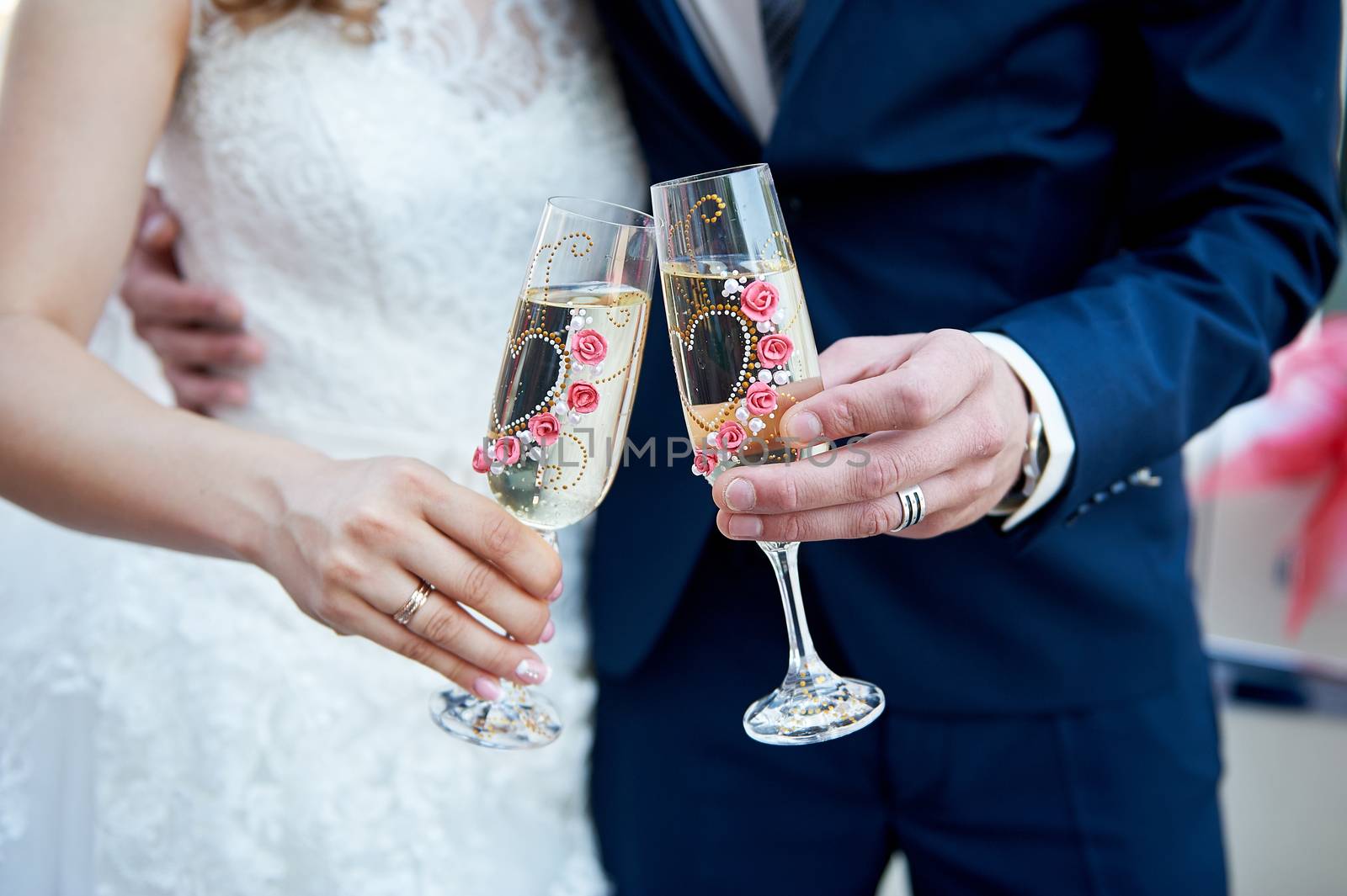 bride and groom are holding champagne glasses.