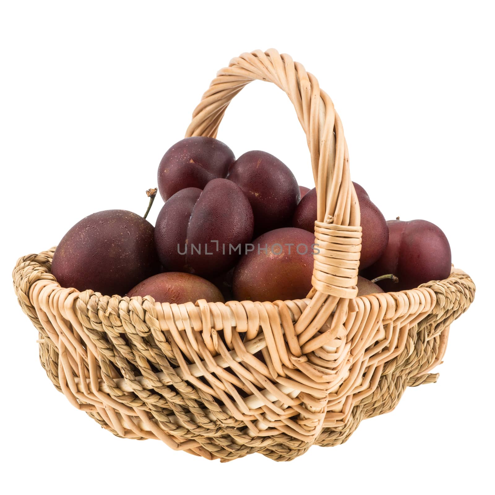 Sweet Plums in the wicker basket isolated on white background. Selective focus.