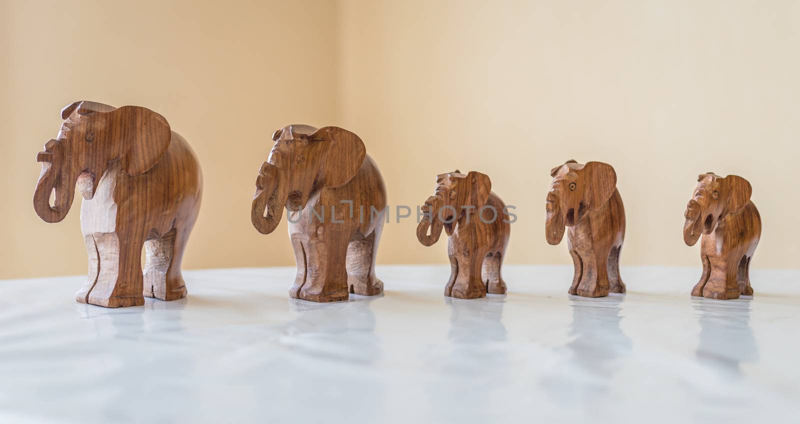 Carved wooden elephants on table by okskukuruza