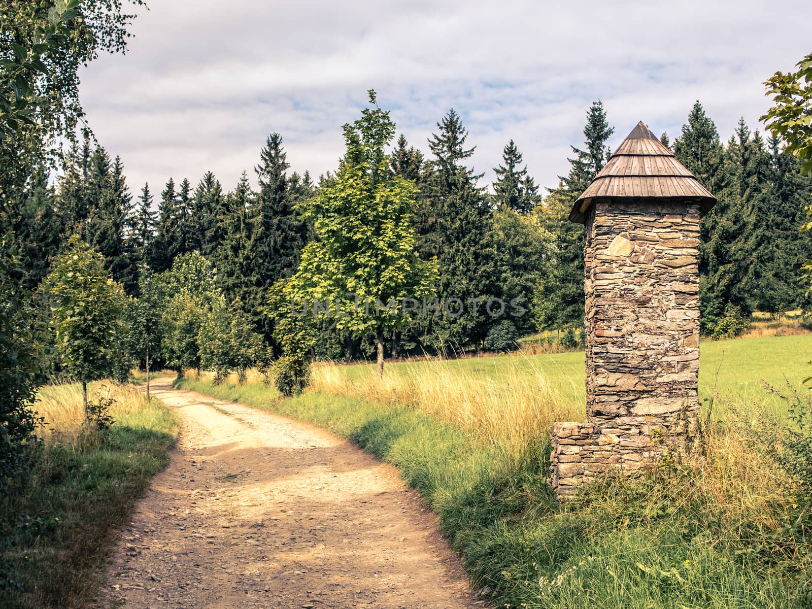Stone chapel on pathway in summer countryside by weruskak