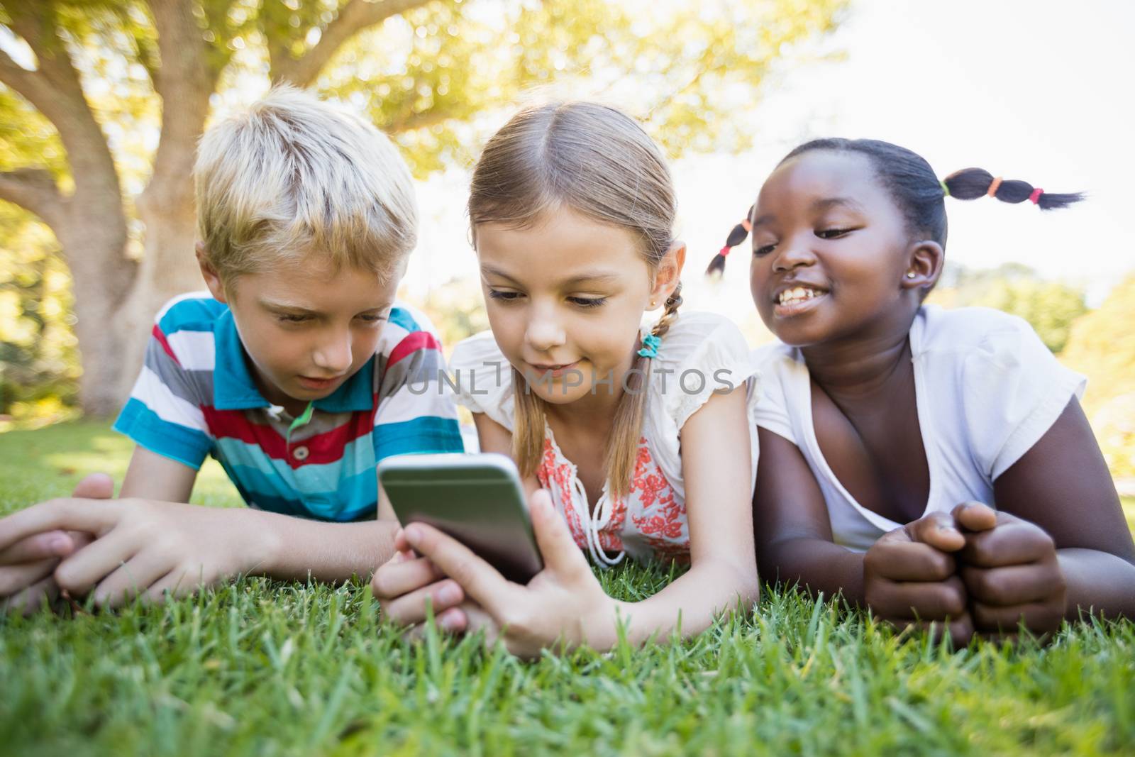 Kids using technology during a sunny day at park