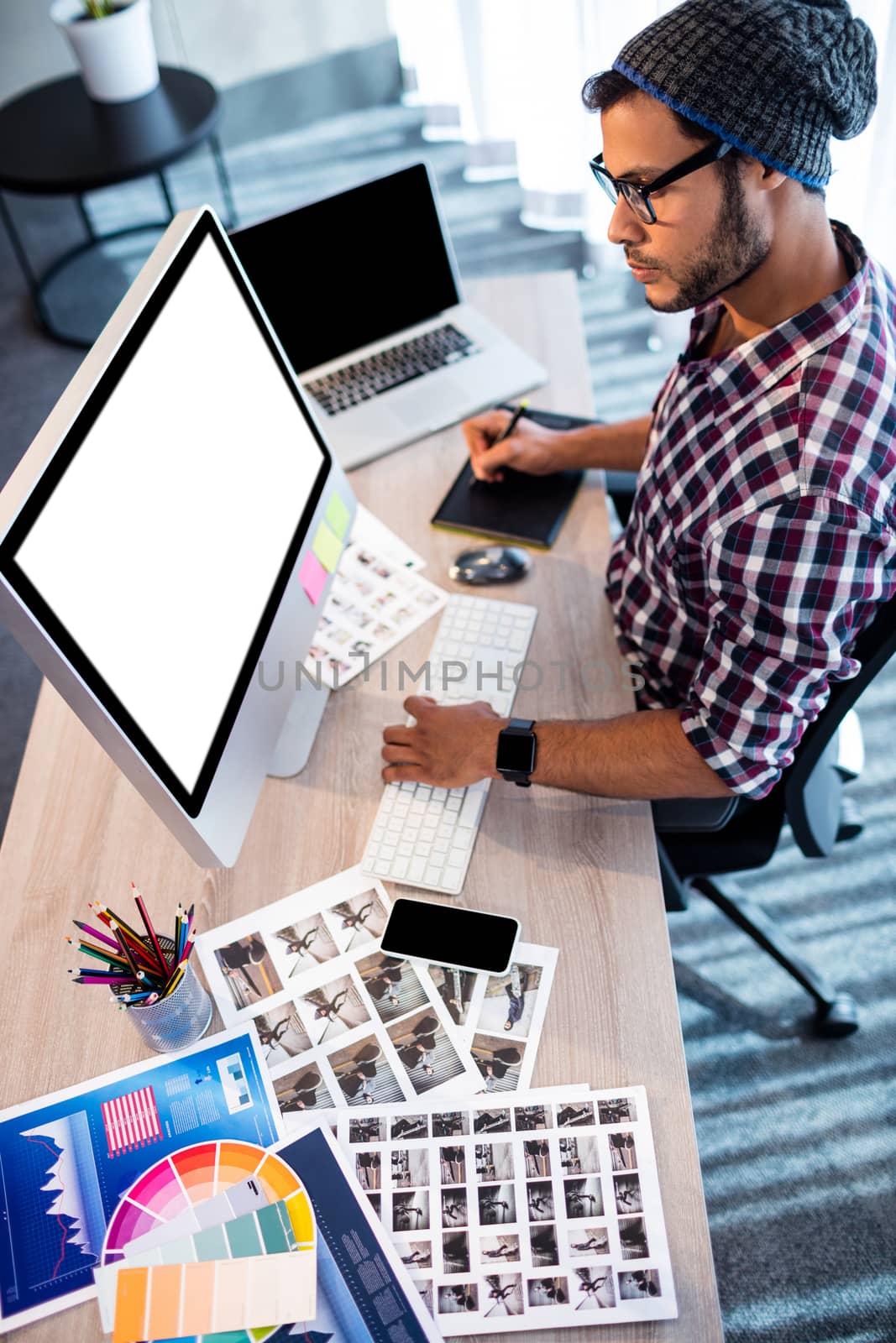 Photographer working at computer desk by Wavebreakmedia