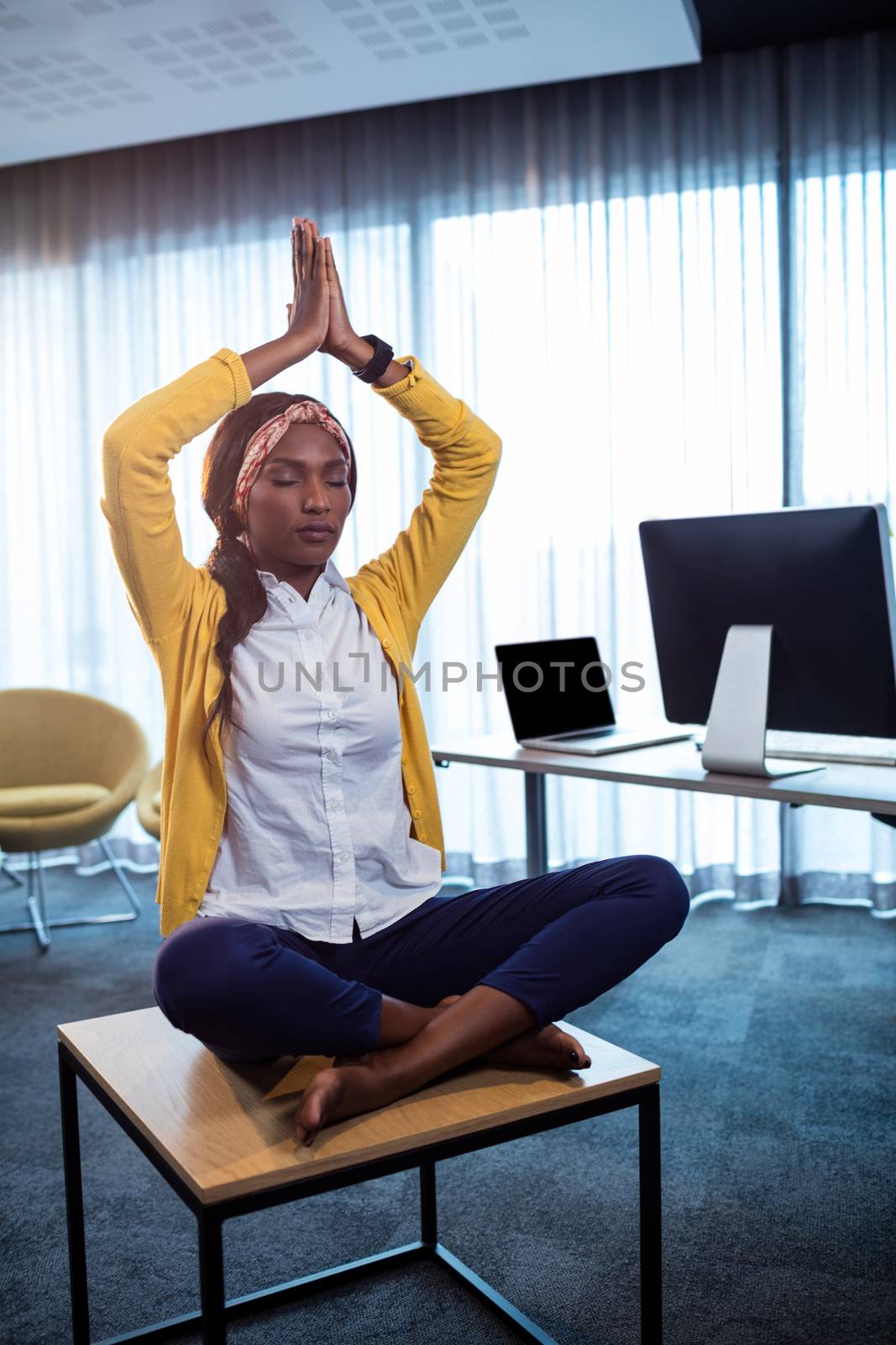 Portrait of businesswoman doing yoga at the office