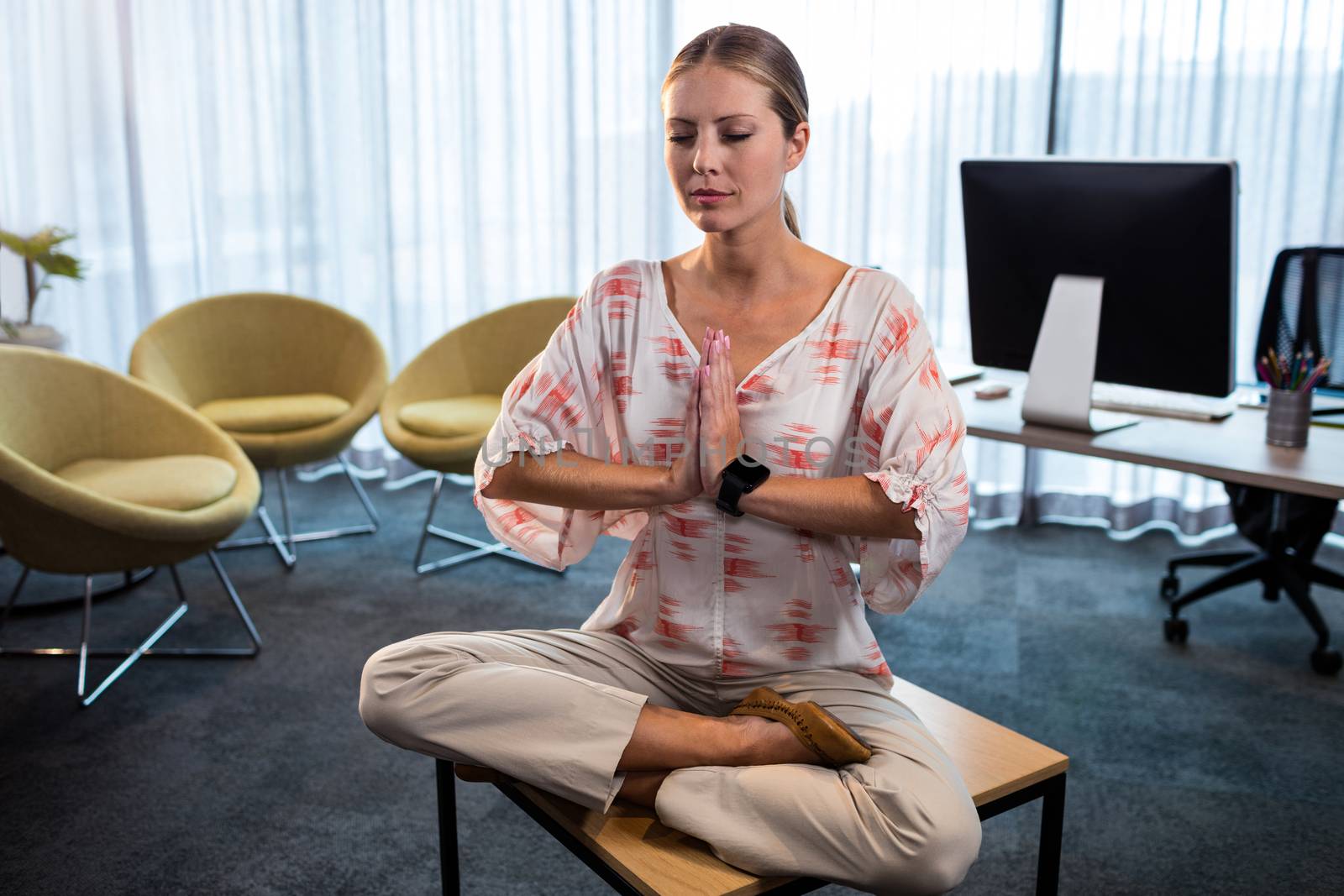 Businesswoman doing yoga with hands tied by Wavebreakmedia