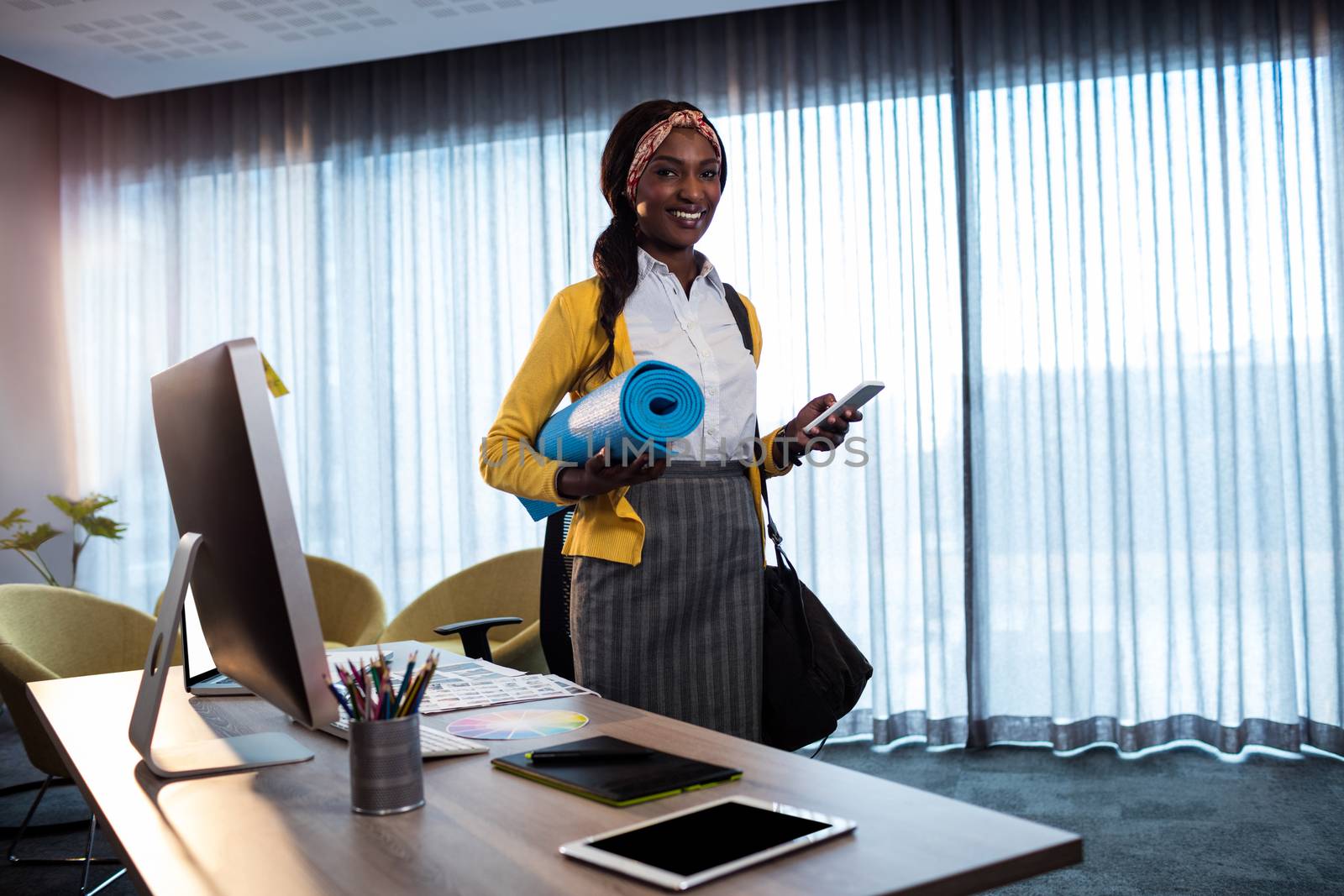 Businesswoman with yoga mat in the office