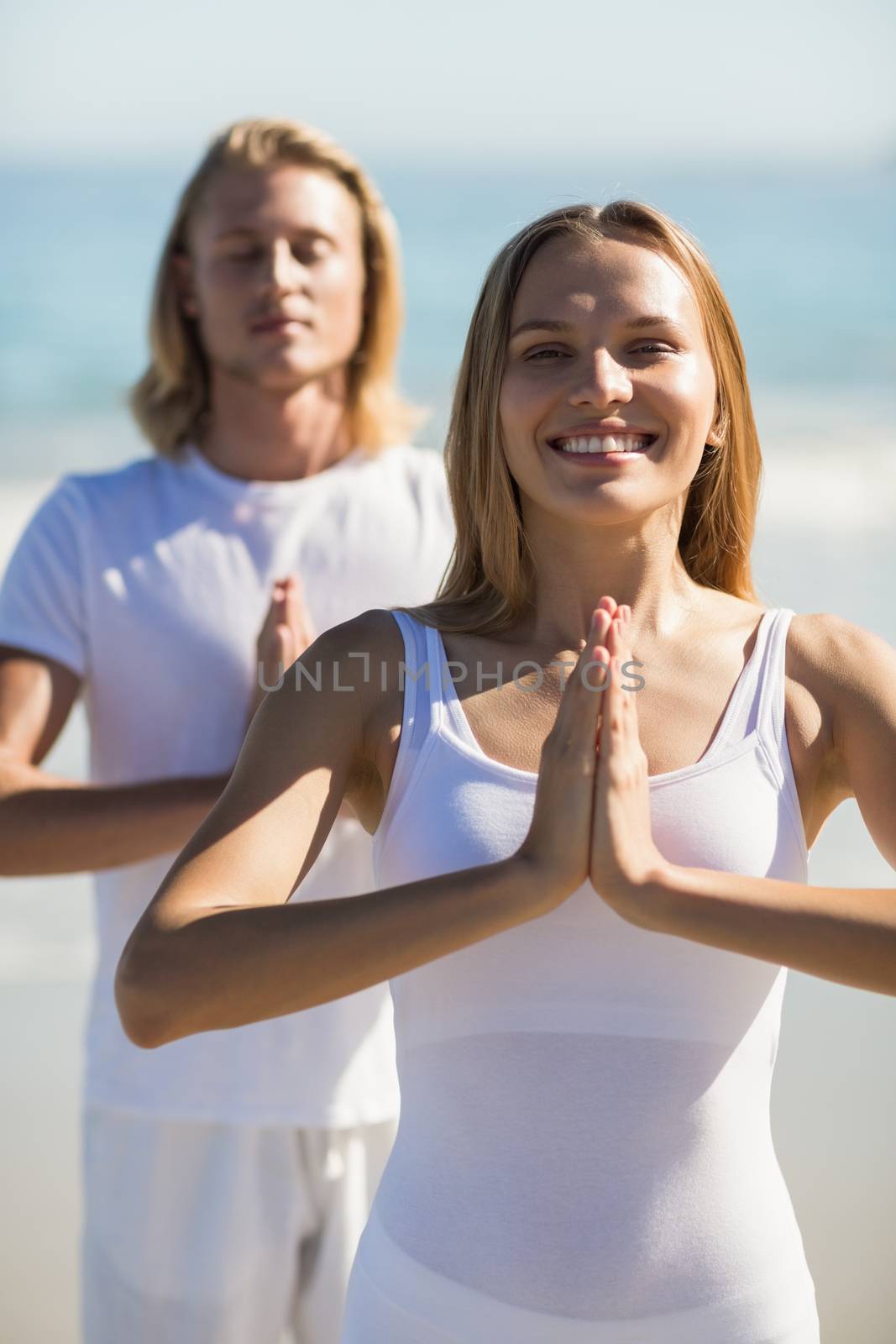 Man and woman performing yoga by Wavebreakmedia