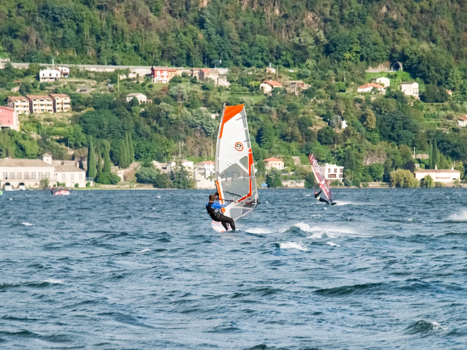 Cremia, Italy - September 5, 2015: Several windsurfing and kitesurfing with thermal wind from the south on Lake Como.