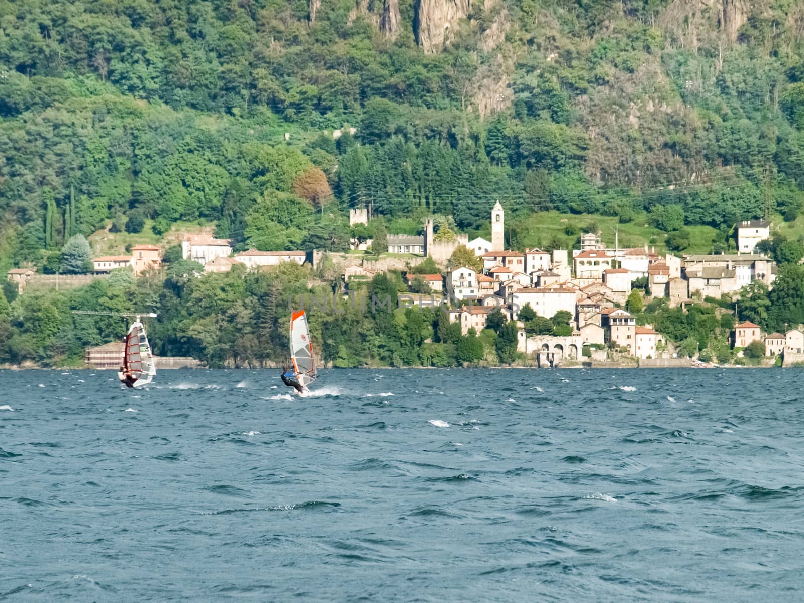 Cremia, Italy - September 5, 2015: Several windsurfing and kitesurfing with thermal wind from the south on Lake Como.