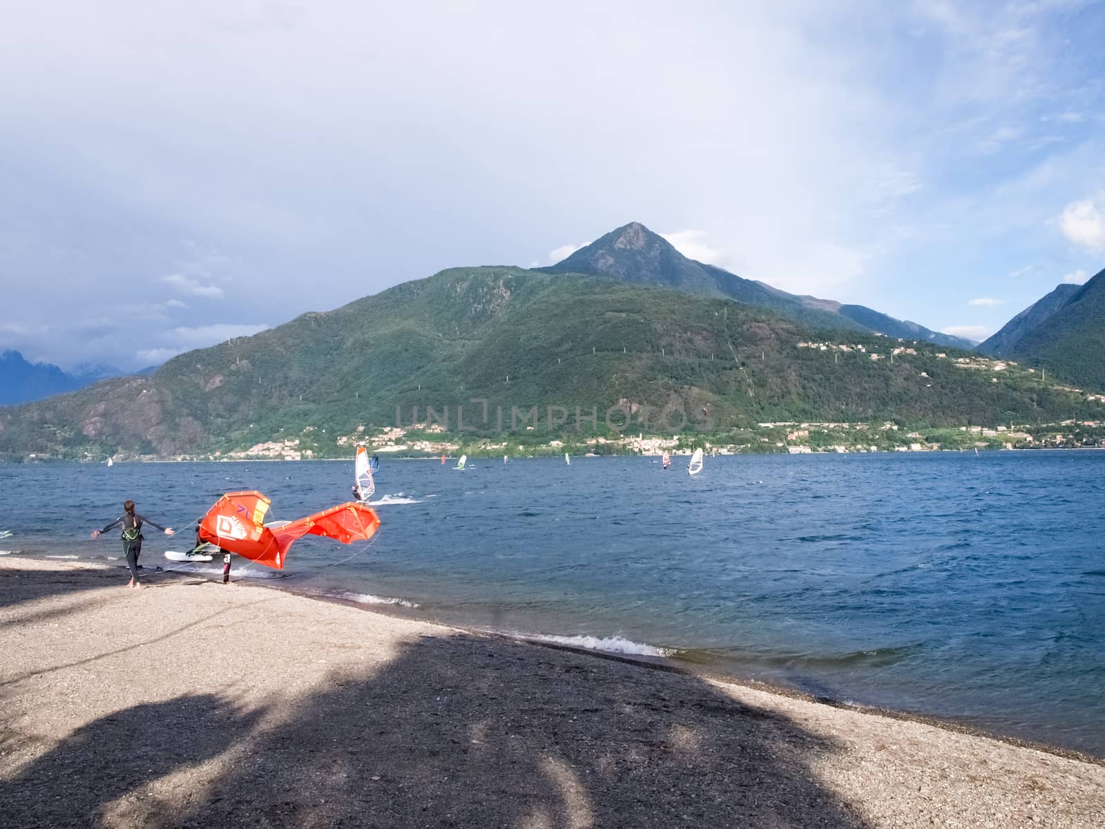 Cremia, Italy - September 5, 2015: Several windsurfing and kitesurfing with thermal wind from the south on Lake Como.