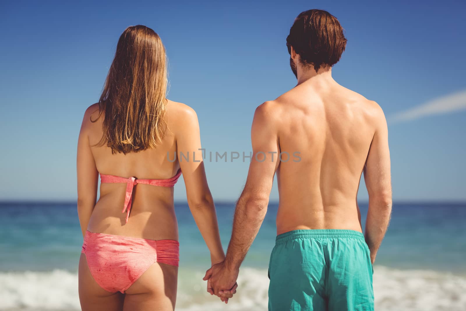 Couple standing on beach by Wavebreakmedia