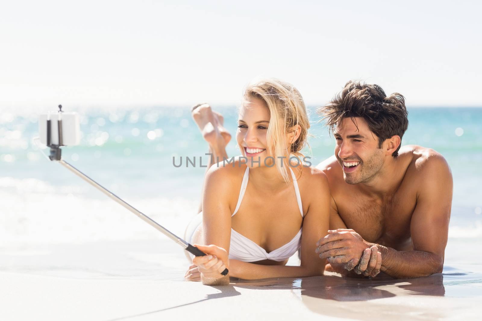 Young couple taking selfie on beach by Wavebreakmedia