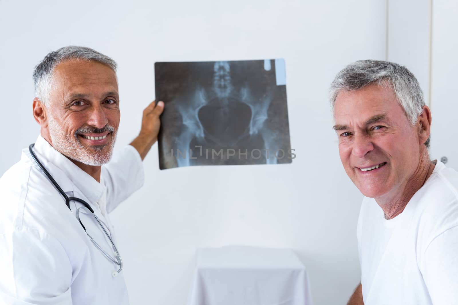 Male doctor discussing x-ray with senior man by Wavebreakmedia