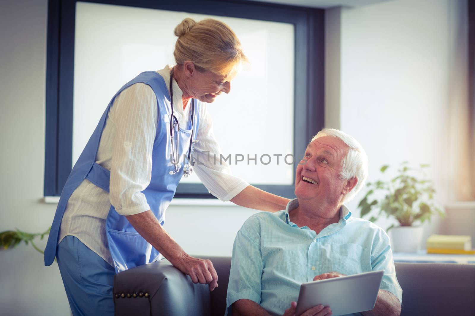Senior man and female doctor interacting with each other by Wavebreakmedia