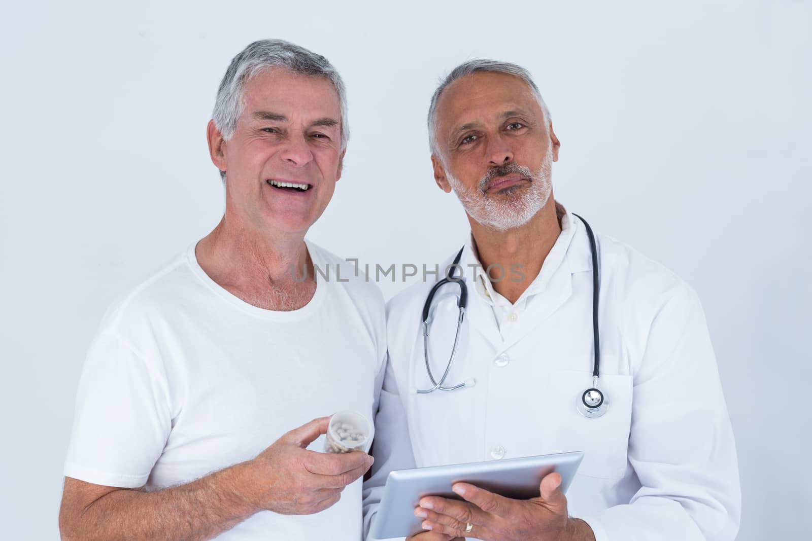 Male doctor showing medical reports to senior man on digital tablet by Wavebreakmedia