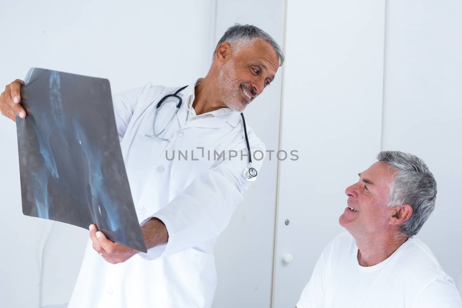 Male doctor discussing x-ray with senior man in hospital