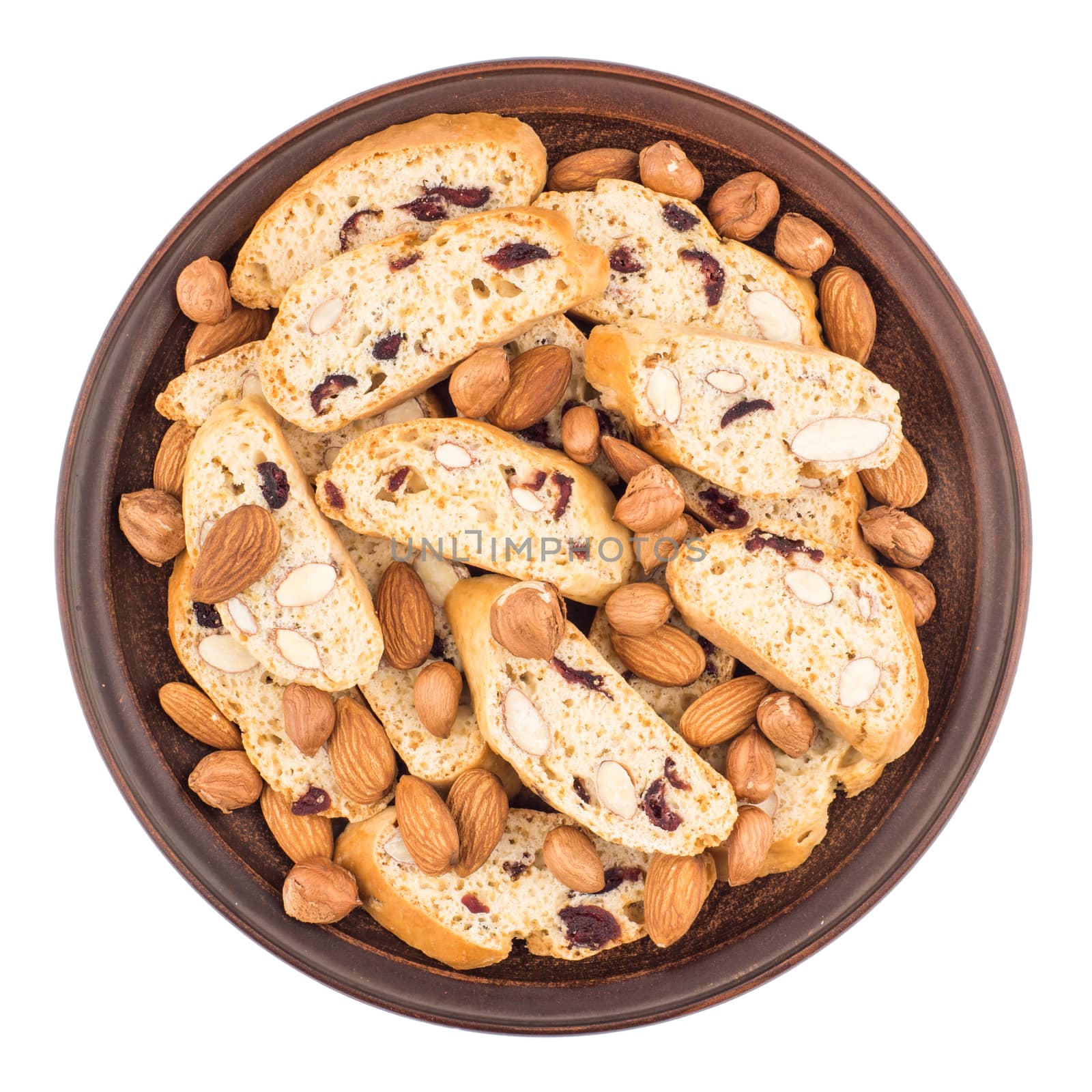 Cookies with raisins and nuts in a ceramic plate. Isolated on white background. Top view.