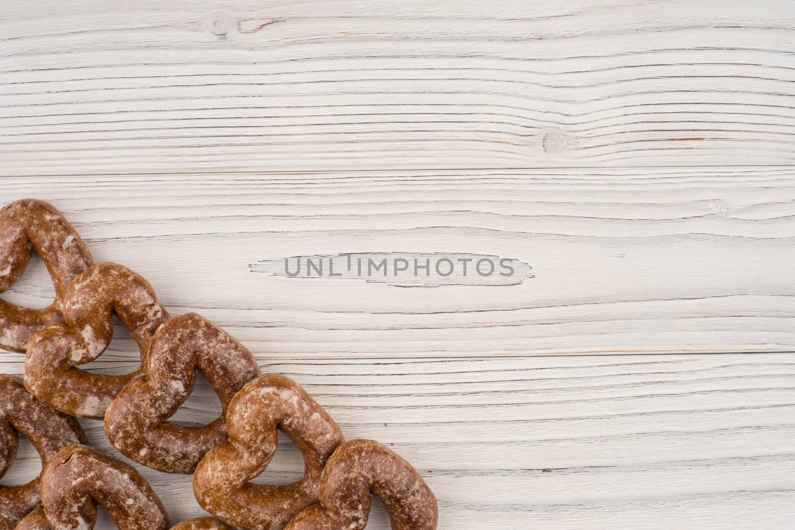 Gingerbread heart cookies on a wooden white background. Top view.