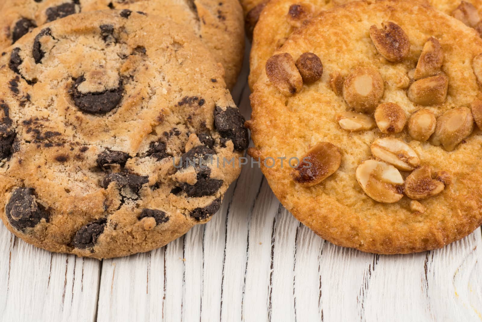 Biscuits with chocolate and peanut on old wooden table. Selective focus.