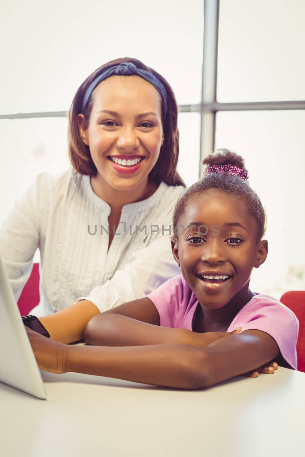Teacher and school girl using digital tablet in classroom by Wavebreakmedia