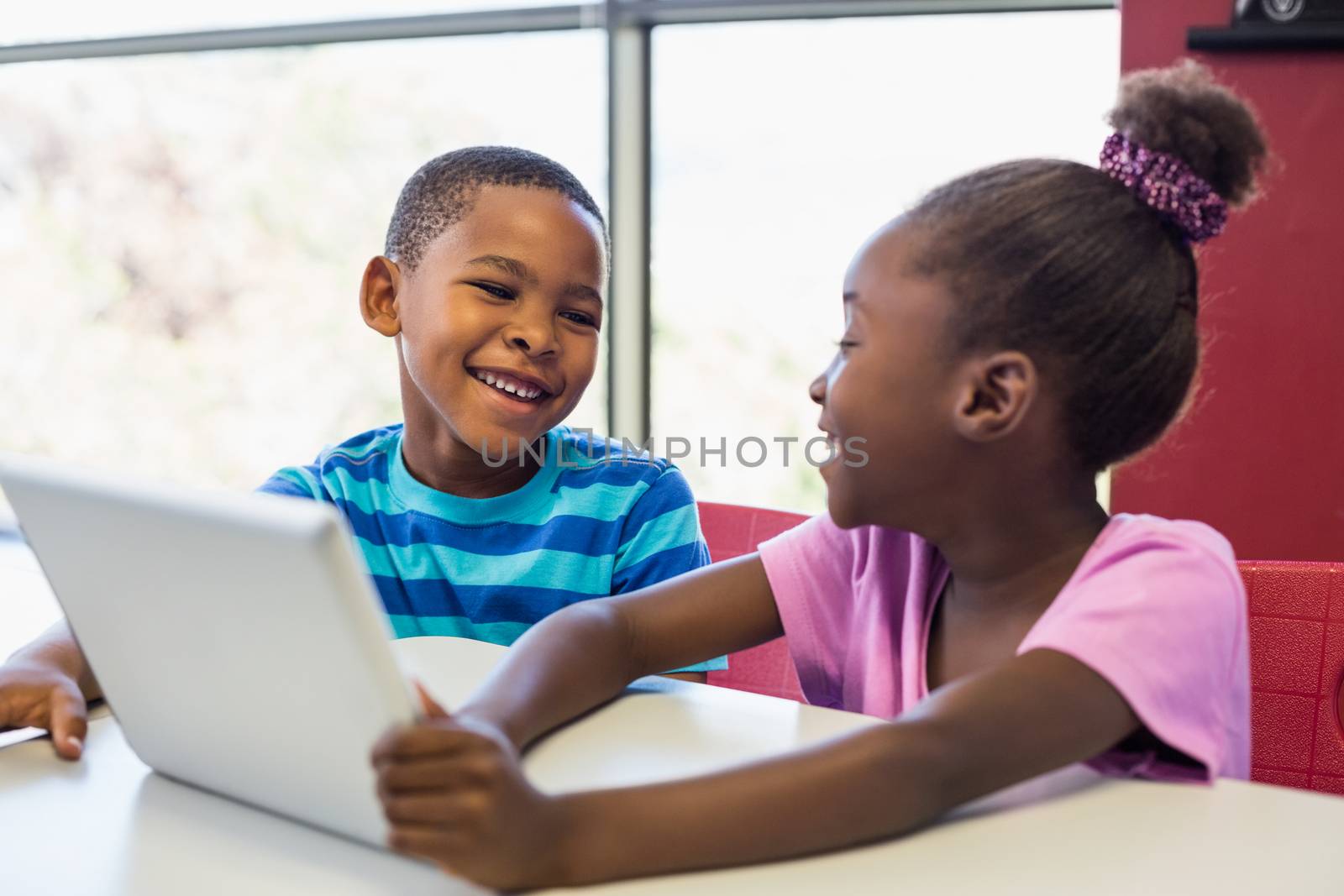 School kids using a digital tablet in classroom by Wavebreakmedia