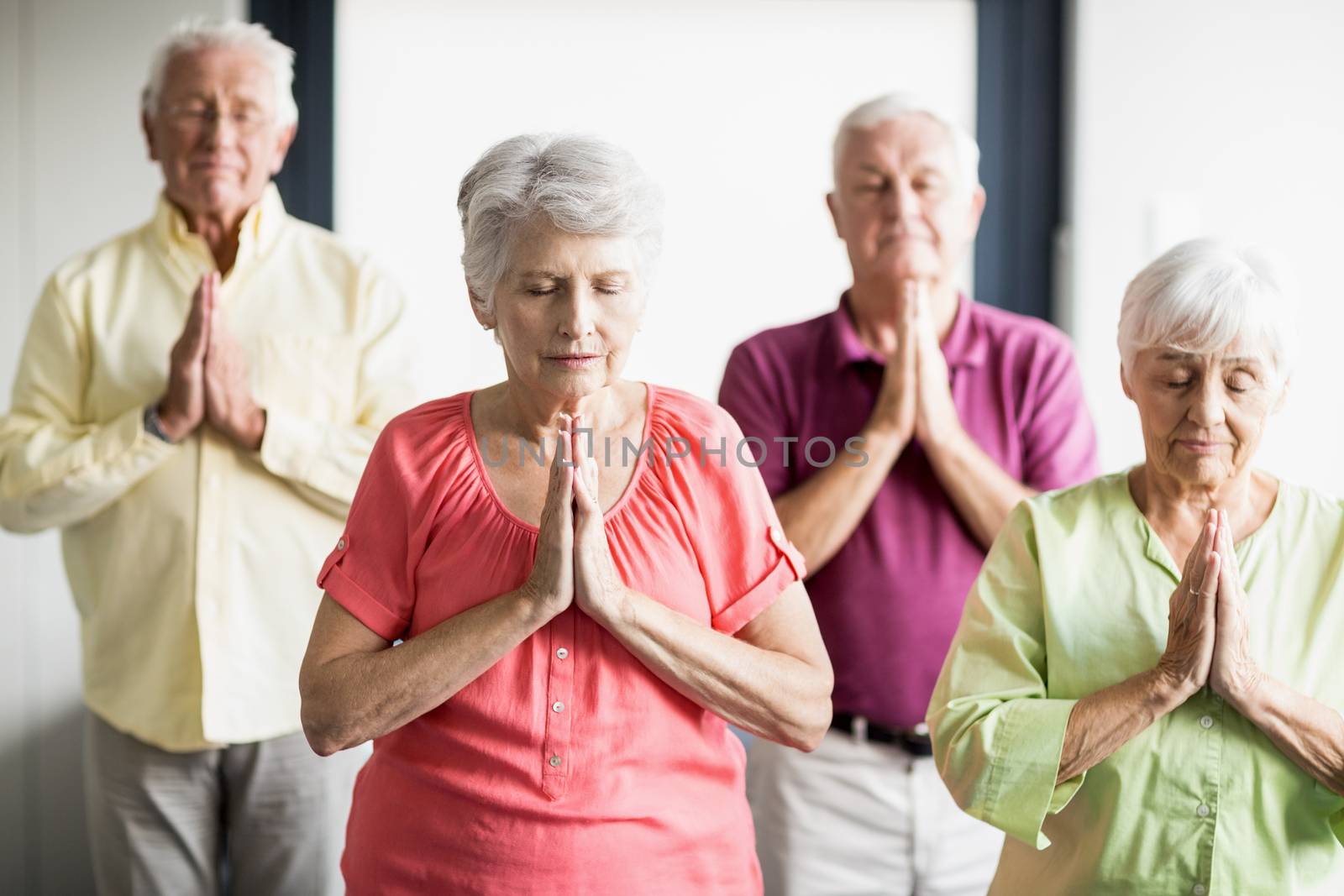 Seniors doing yoga with closed eyes by Wavebreakmedia