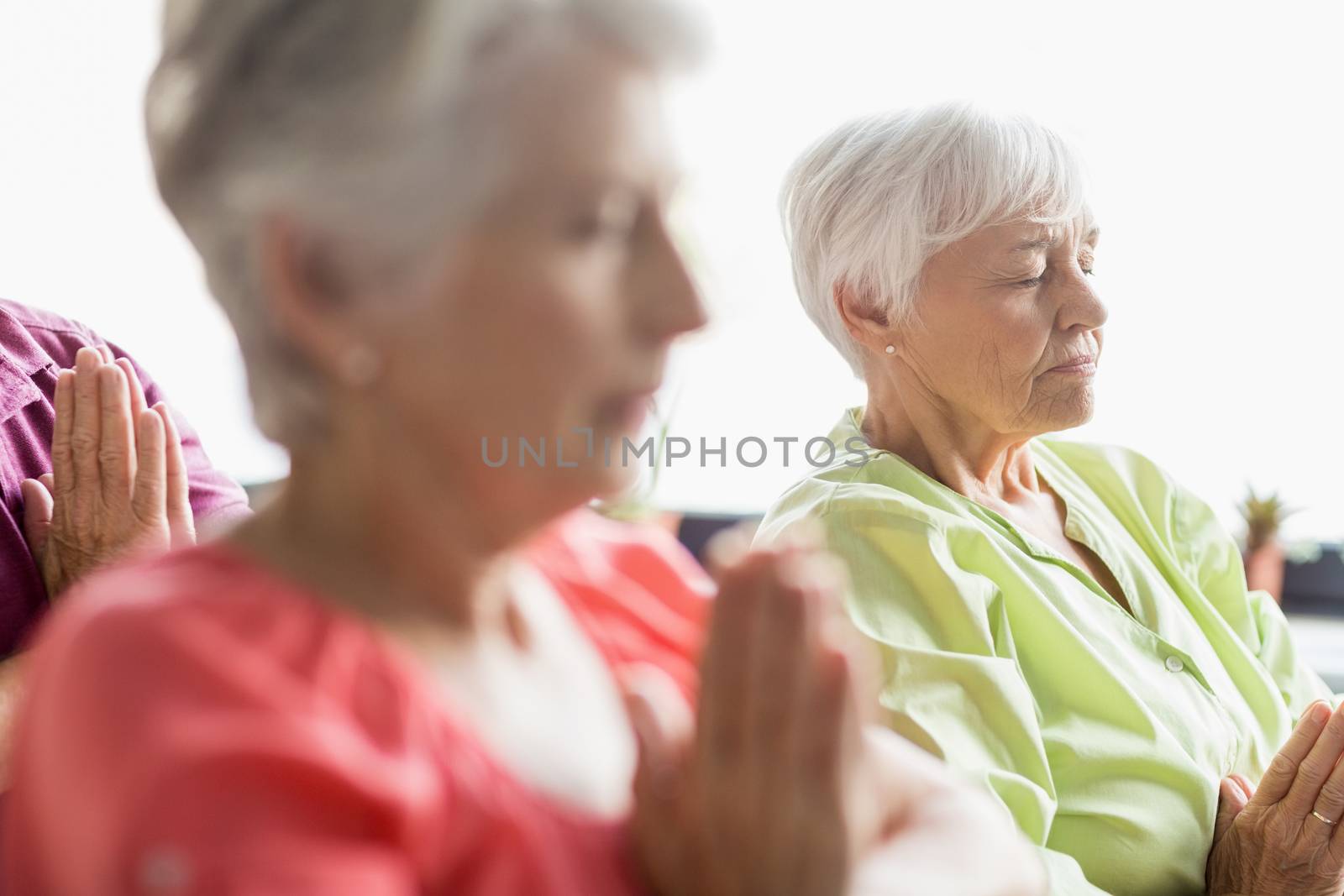 Seniors doing yoga with closed eyes by Wavebreakmedia