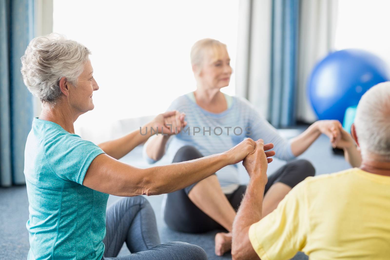 Seniors performing yoga during sports class