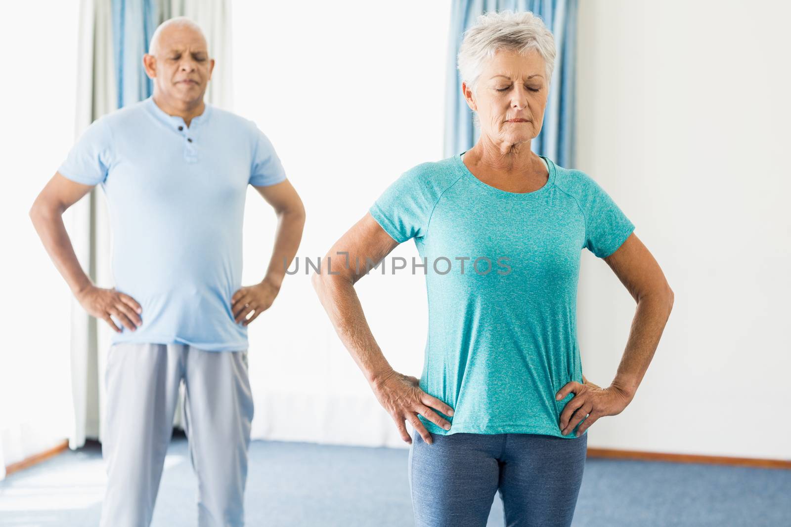 Seniors performing yoga in a studio