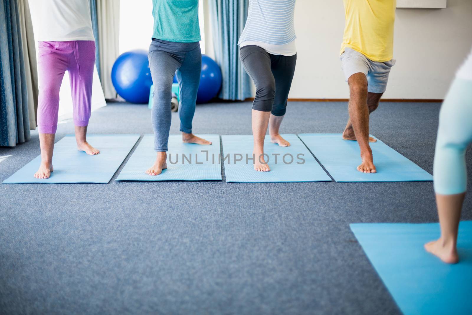 Instructor performing yoga with seniors during sports class