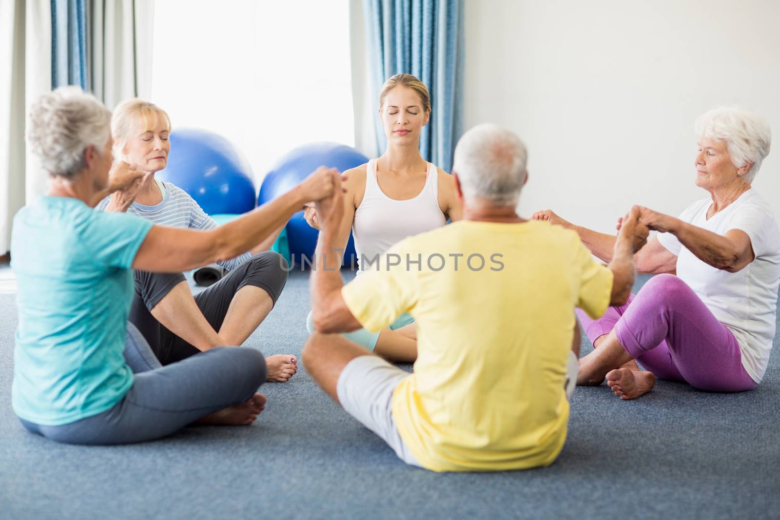 Seniors performing yoga during sports class