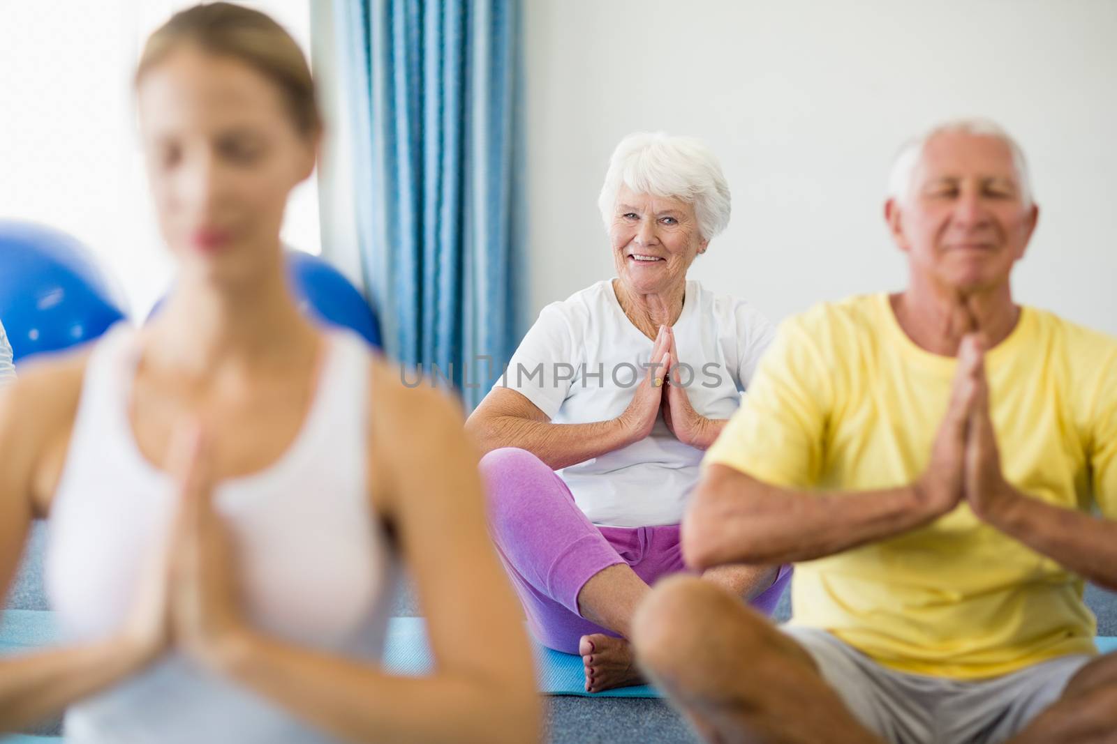 Instructor performing yoga with seniors by Wavebreakmedia