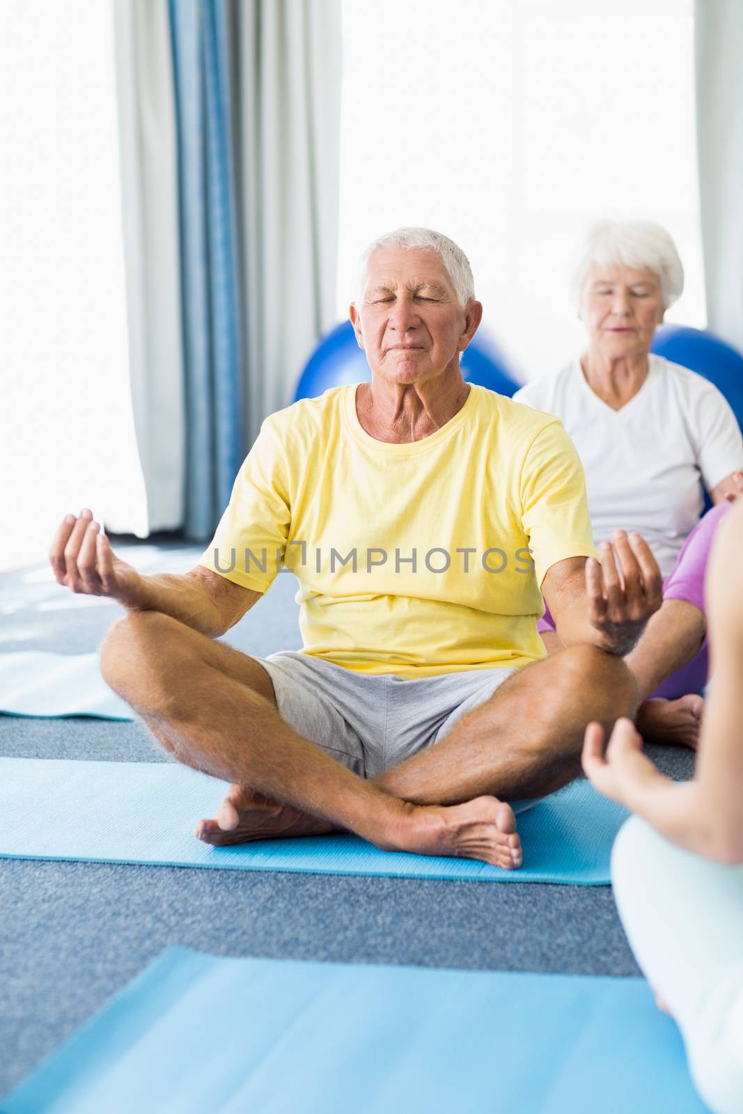 Seniors performing yoga by Wavebreakmedia