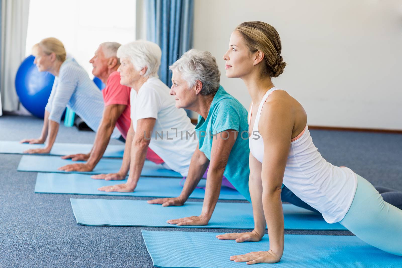 Instructor performing yoga with seniors by Wavebreakmedia