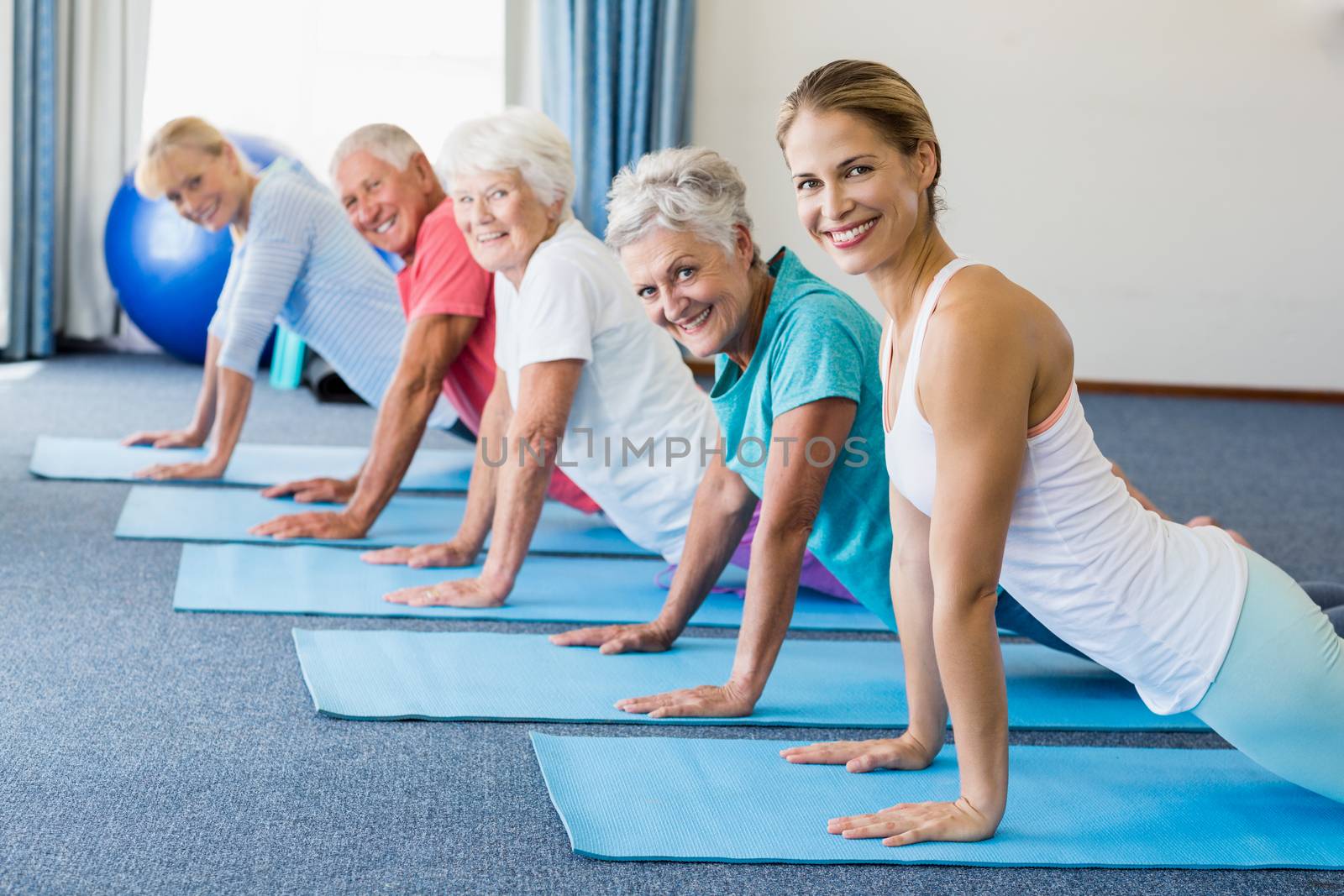 Instructor performing yoga with seniors by Wavebreakmedia