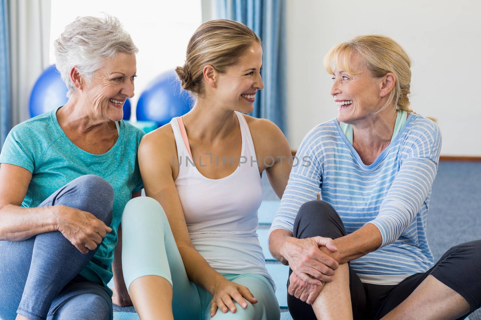 Instructor and senior women sitting in a studio