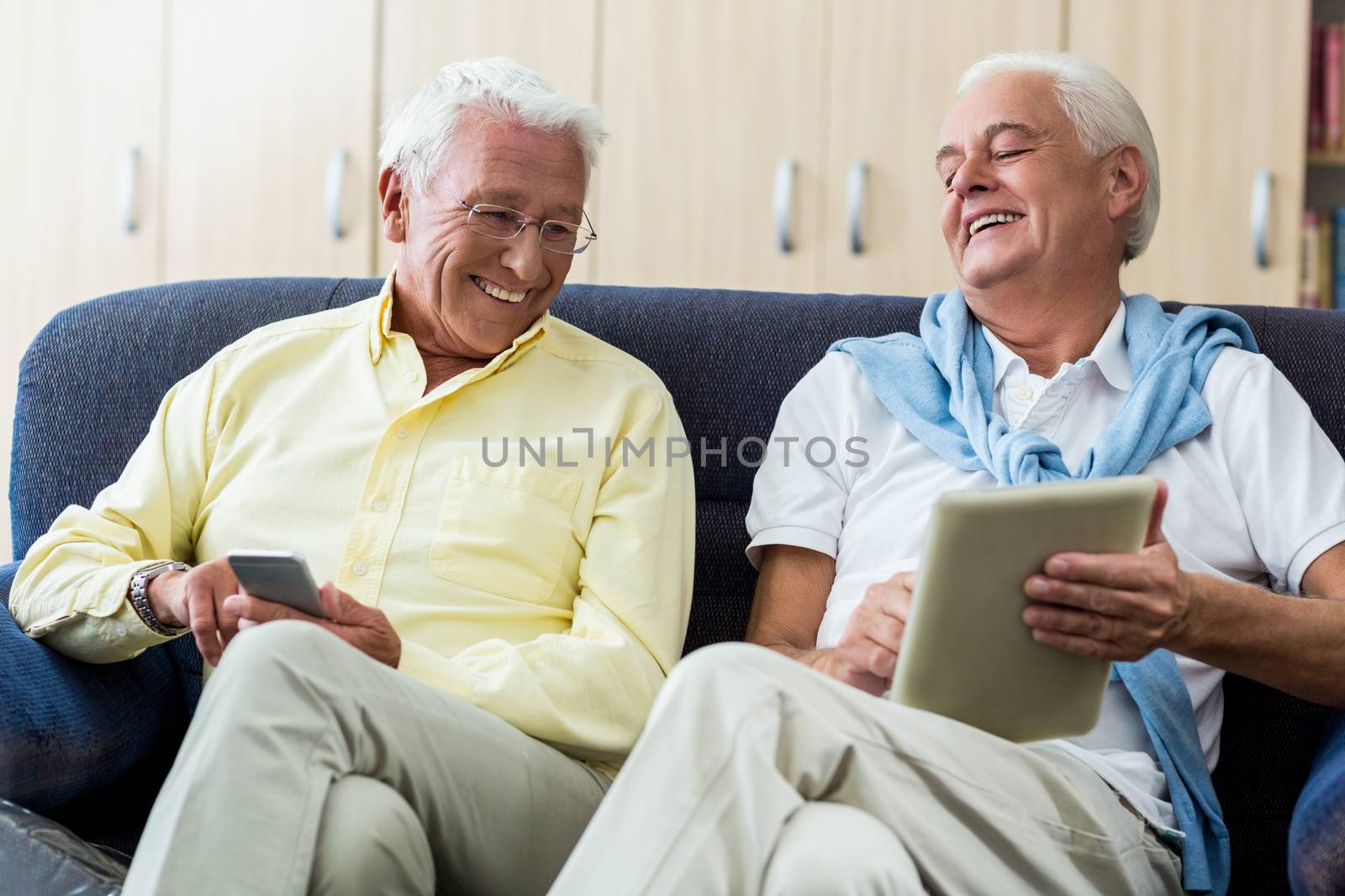 Senior men using technology in a retirement home